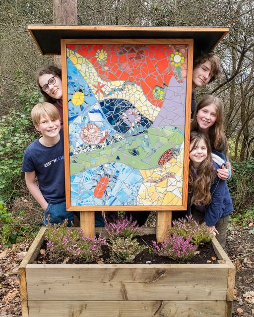 Evan and Aaron Cullen, Sylva and Theia Sepight Murphy, and Sophie Schriever alongisde one of the mosaics they worked on.