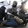 Federal immigration officers detain a person observing them on Jan. 13, 2026, in Minneapolis. After being arrested, some protesters have said federal officers took samples of their DNA.
