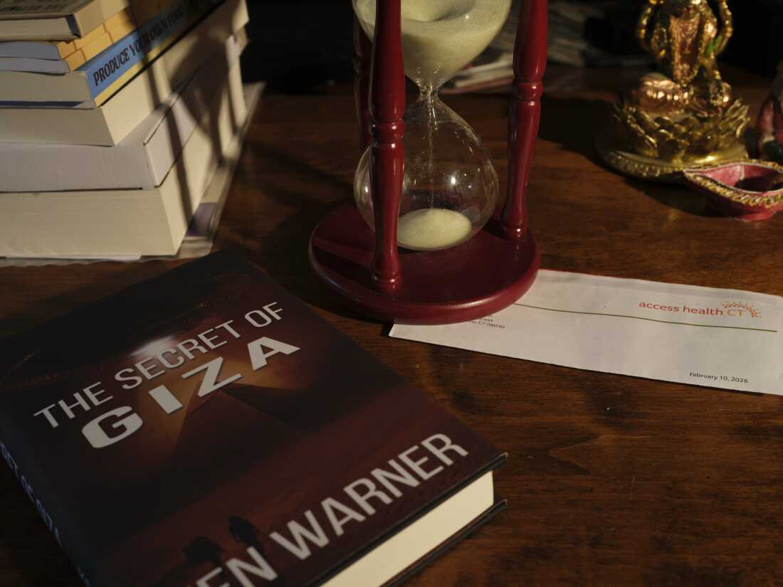 Ken Warner's novel, The Secret of Giza, is the first in a 10-volume series about twins who "are thrust into a war that spans worlds," according to the book description. There's an Access Health CT letter on the desk, too.