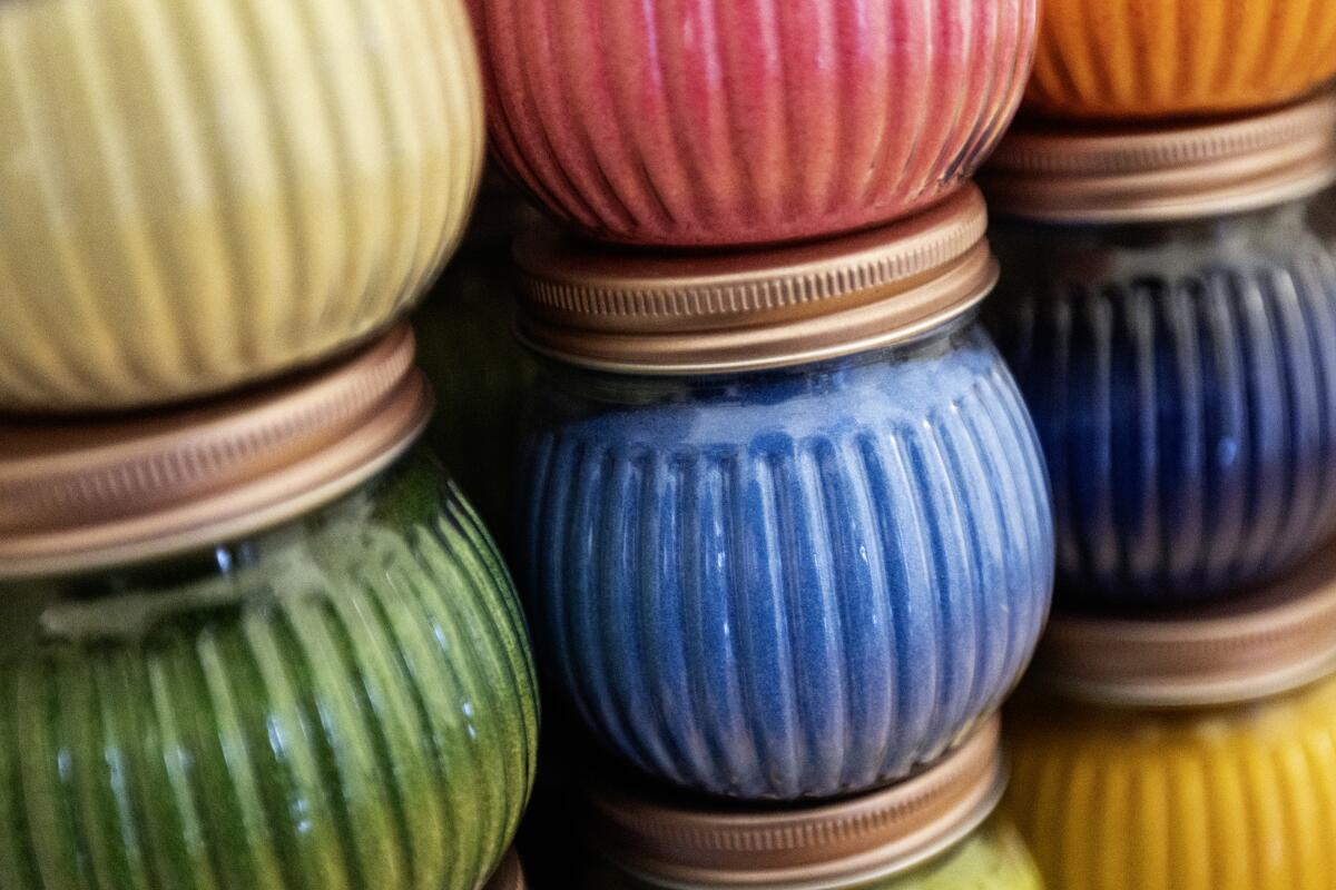 Jars containing colorful sand are displayed.