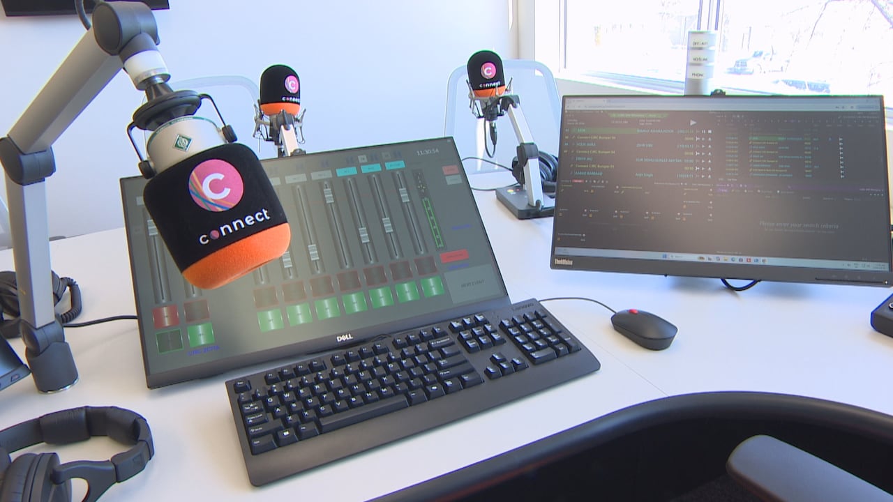 A desk with a computer showing an audio board is shown with an orange and black microphone at says "connect" and a pink logo with the letter C in a circle