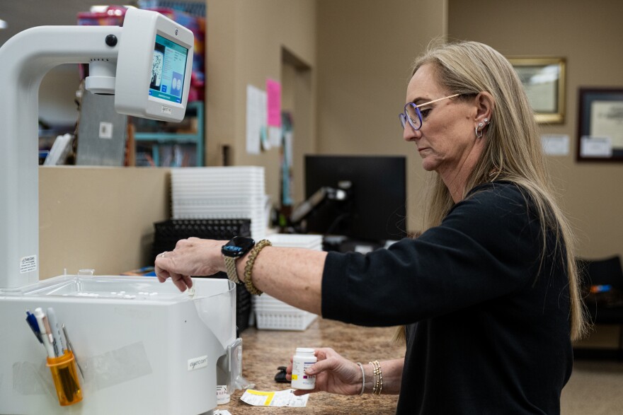 Crystal McEntire, who owns Hyland’s Pharmacy, counts out pills to fill a patient’s prescription.