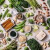 This photo shows a variety of planted-based sources of protein — legumes, nuts, grains and vegetables — photographed from above.