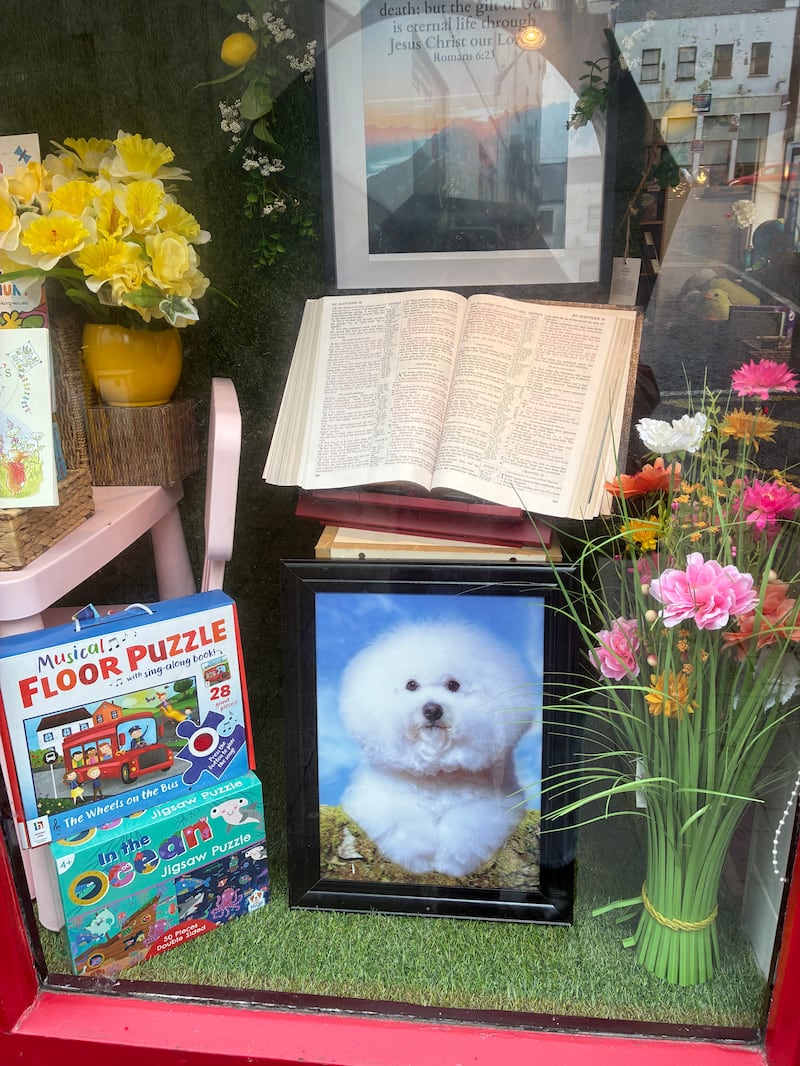 The Burke family's  shop window display of children’s books and games and a Bible, opened on a page about The Parable of the Two Sons