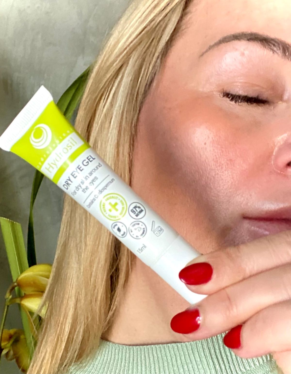 A woman holding the Hydrosil Dry Eye Gel close to her face