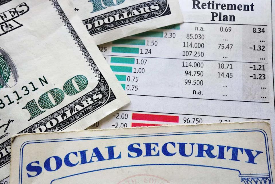 A close-up shot shows a stack of hundred-dollar bills partially covering a document titled 'Retirement Plan' which displays columns of numbers and bar graphs. In the foreground, the corner of a Social Security card is visible, showing the words 'SOCIAL SECURITY' in blue capital letters.