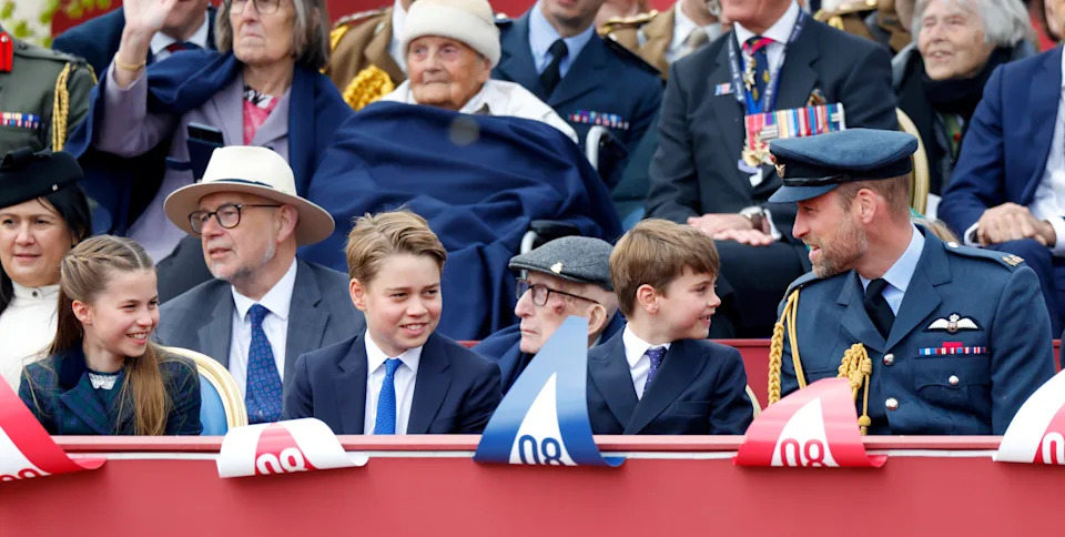 Princess Charlotte, Prince George, Prince Louis and Prince William sitting in a row at a VE Day parade