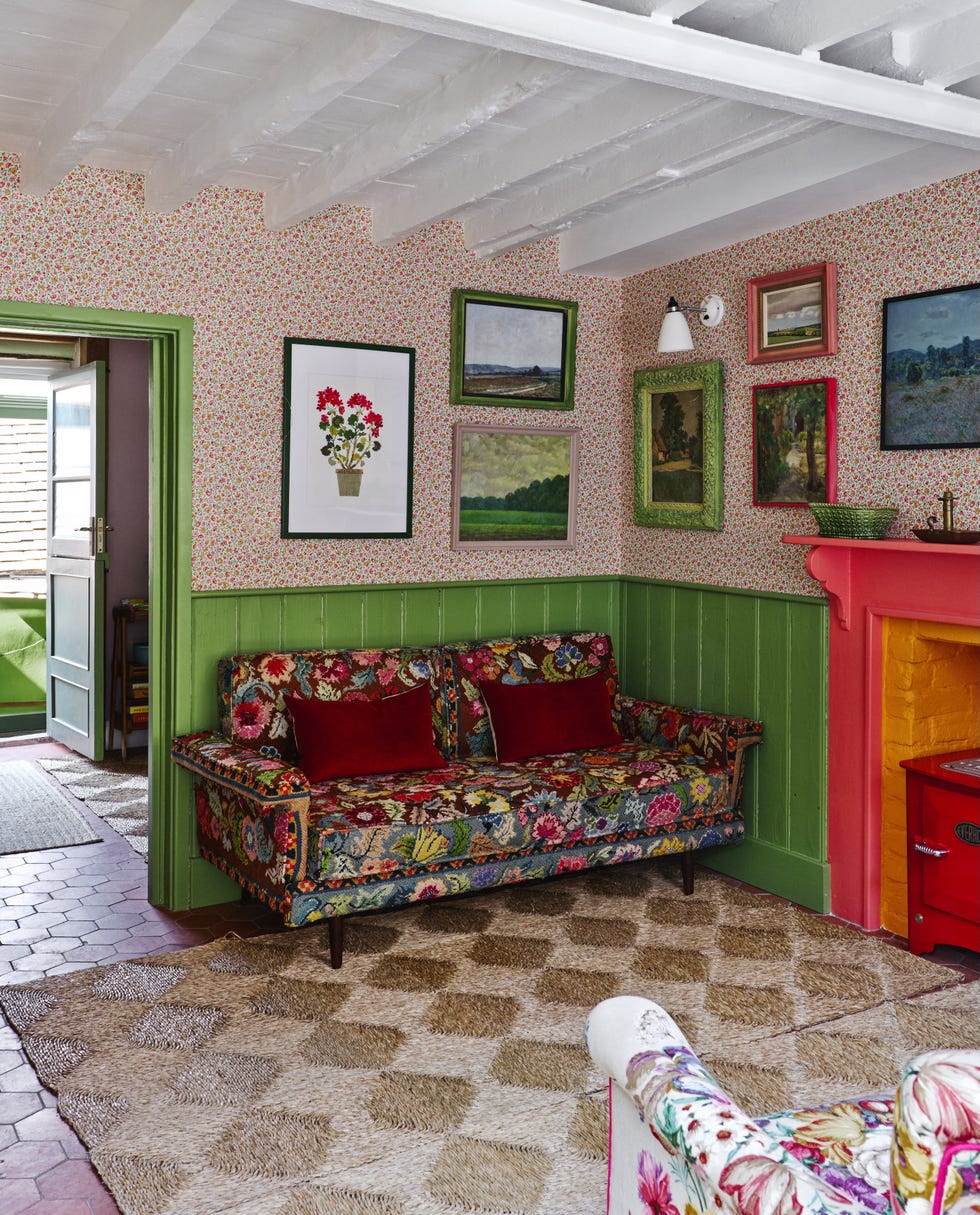 eclectic living space with floral wallpaper, painted beams, vintage furniture and red check curtains