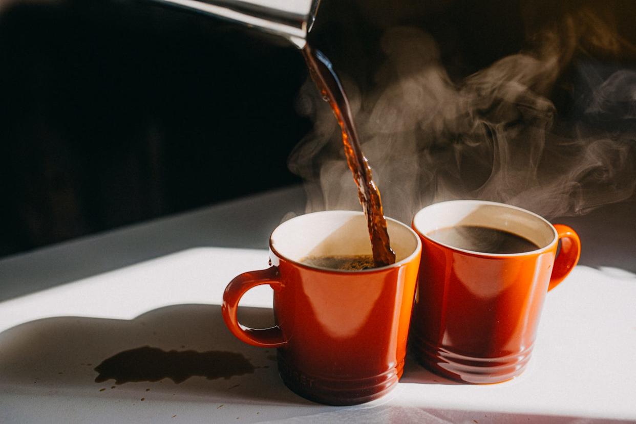 coffee pouring in two mugs