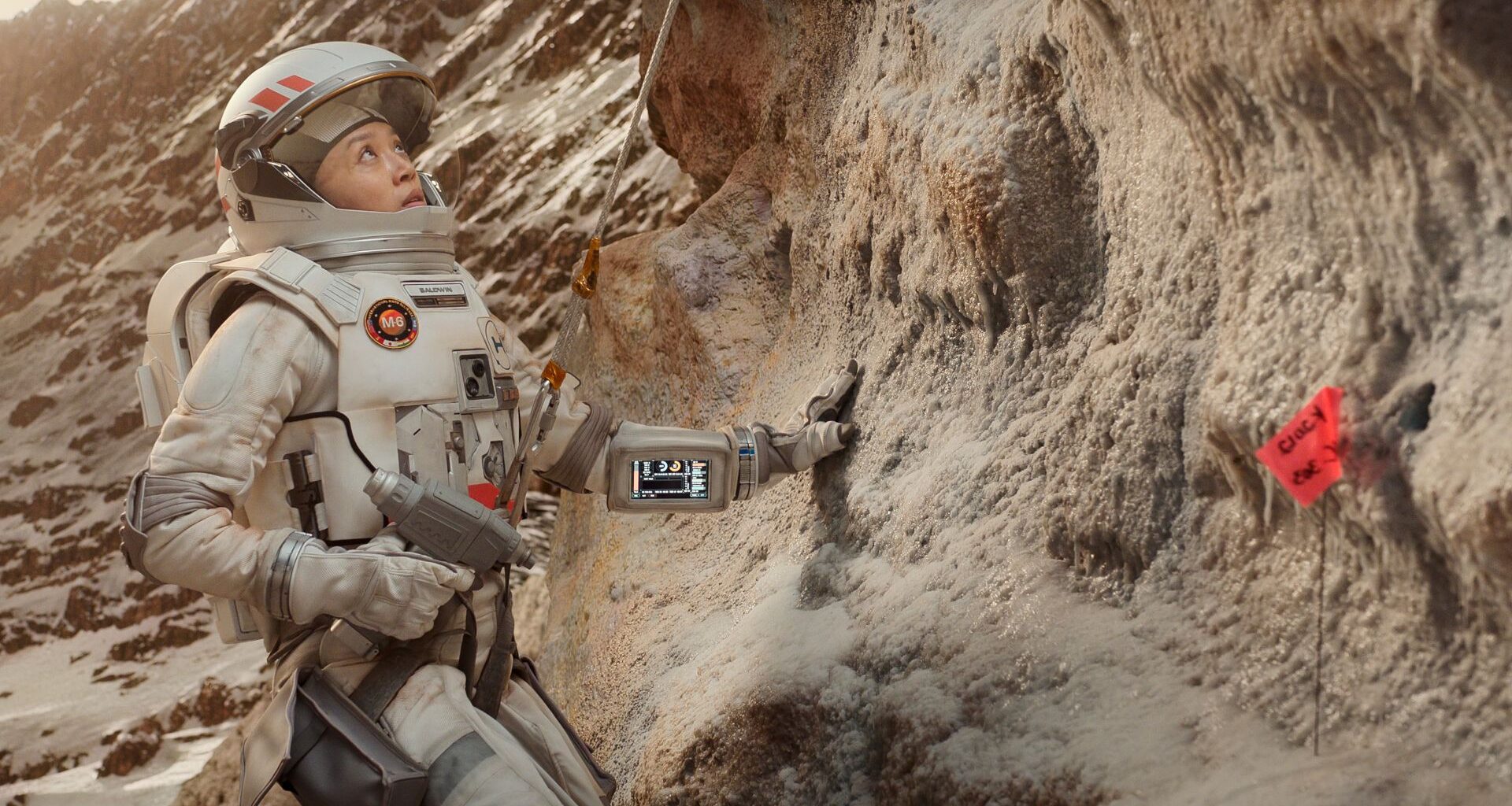 a woman in a spacesuit doing geological tests