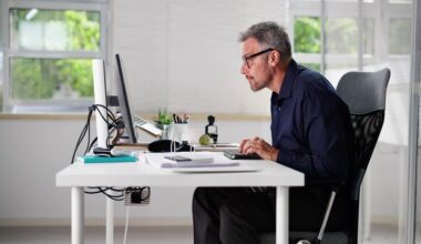 Man with bad posture sitting in office chair at computer desk