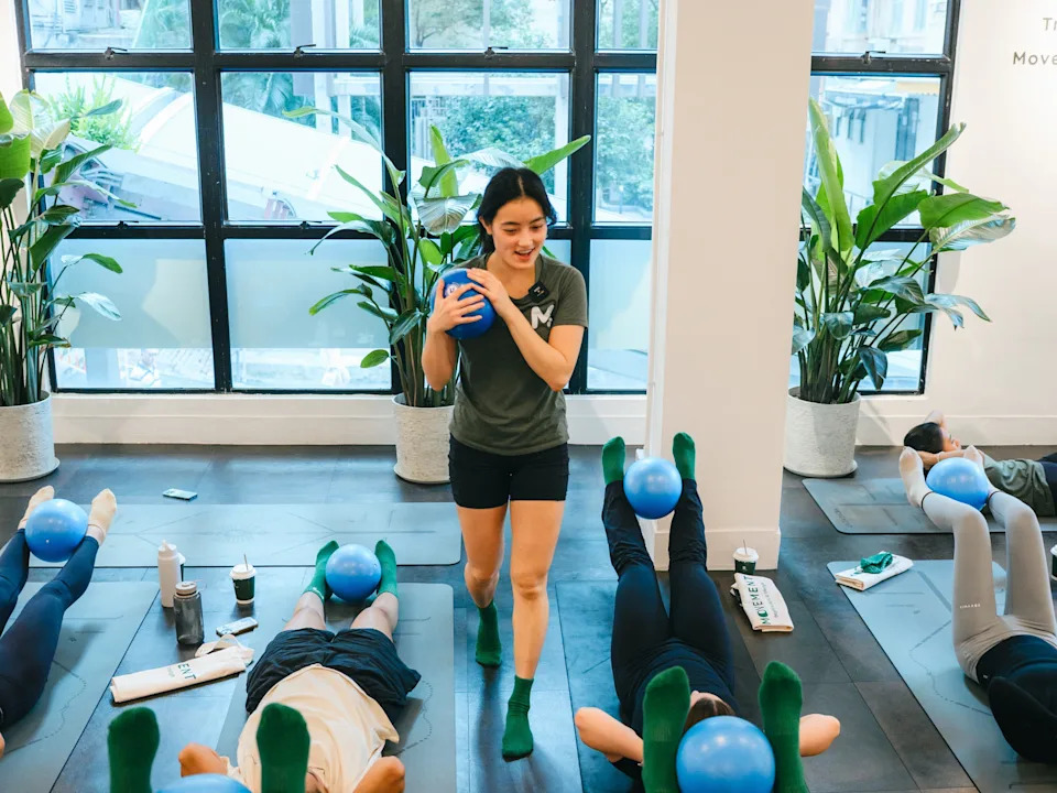 A woman teaching a fitness class at a gym in Hong Kong.