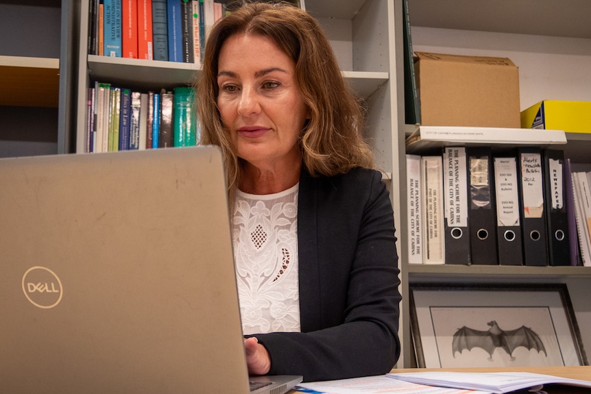 A lawyer, her laptop open at a desk.