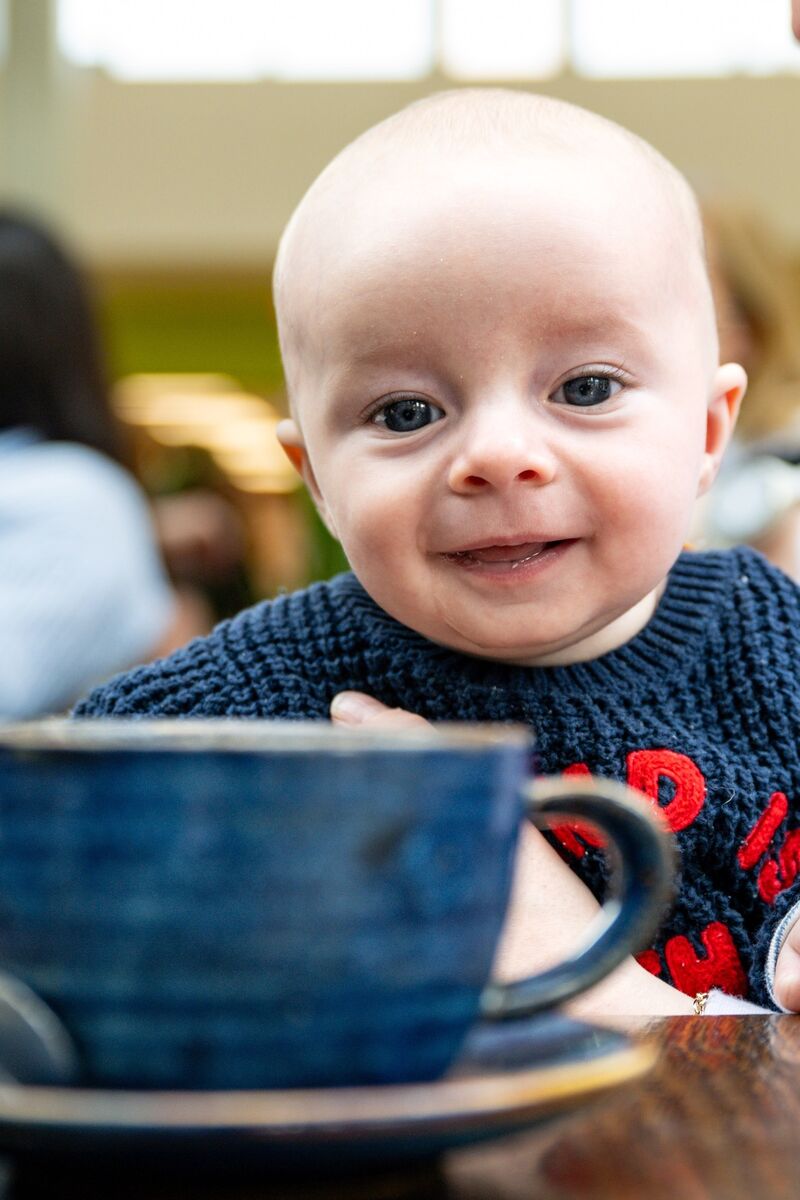 A young attendee pops his head up over a cup of coffee during the Irish Examiner Parenting coffee morning at Here’s Health in Douglas Court Shopping Centre. Picture Chani Anderson