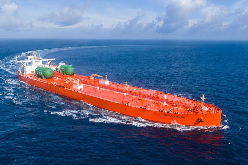 An aerial shot of a red oil tanker with two green LPG tanks on its deck.