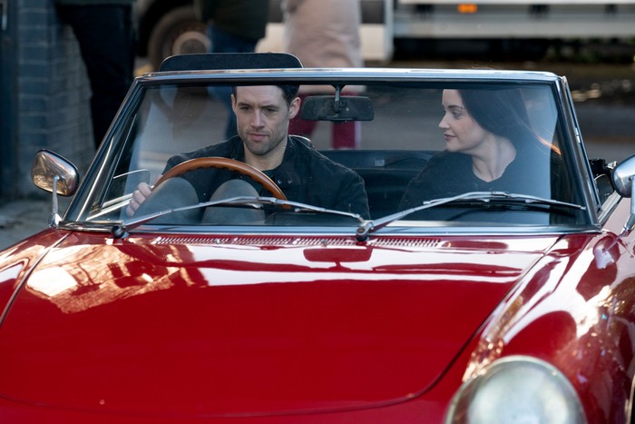 Lauren and Mark sat in a classic red car in a scene from EastEnders