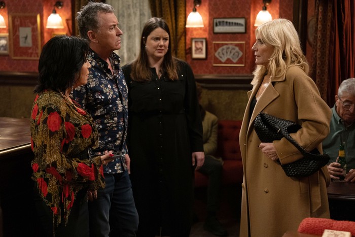 Cindy stares towards Alfie, Kat and Zoe in The Queen Vic in EastEnders