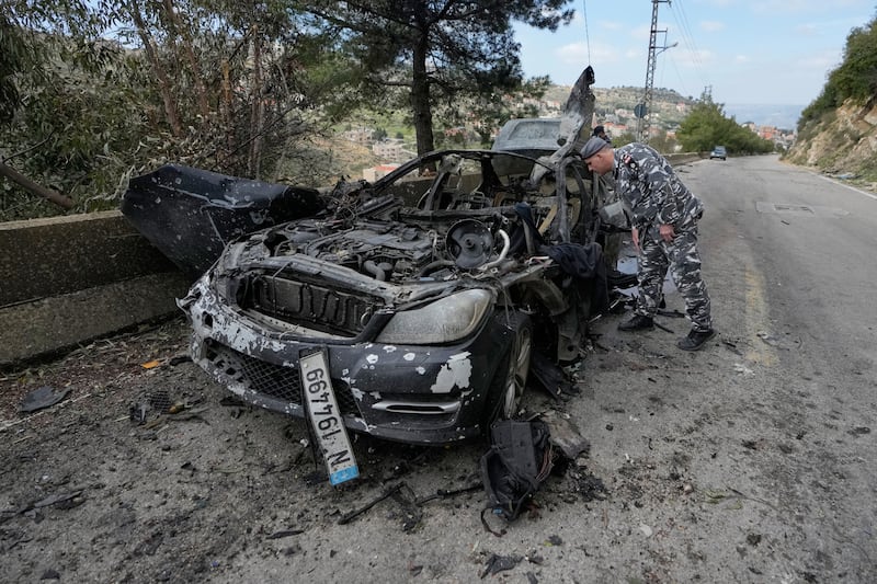 A policeman checks the charred car that was carrying Hizbullah’s al-Manar TV correspondent Ali Shoeib. Photograph: Mohammed Zaatari/AP