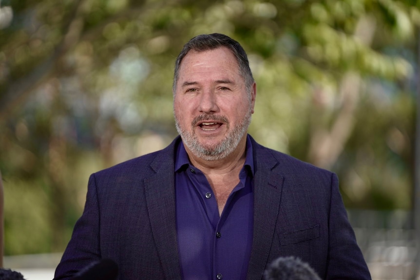 Andrew Powell wears a blue shirt and dark jacket