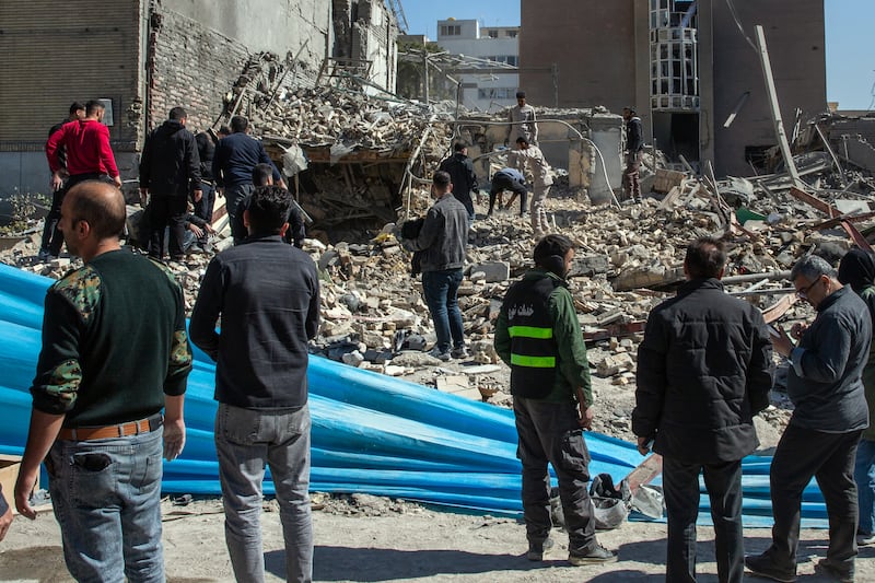 Workers in Tehran clear rubble at the site of a police station destroyed by US-Israeli air strikes. Photograph: Arash Khamooshi/New York Times
                      