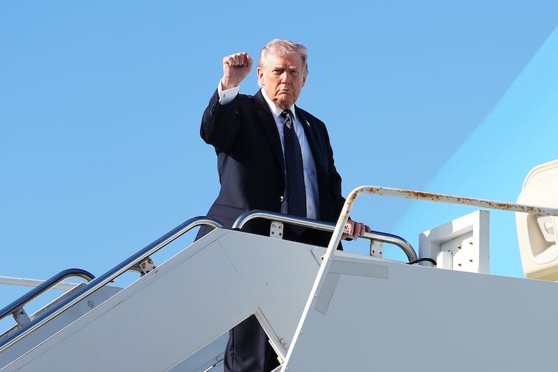 Donald Trump holds up a fist as he boards Air Force One following delivering an update on Truth Social on the attacks on Iran. Photograph: Eric Lee/The New York Times
                      