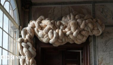 Large knotted woollen shapes above a door frame in a house. The walls are marbled.