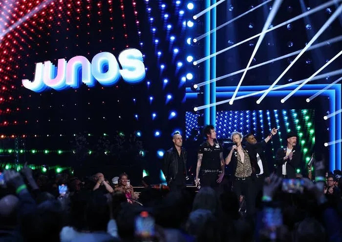 Performers on stage at the Junos, with a dynamic light display in the background and audience in foreground
