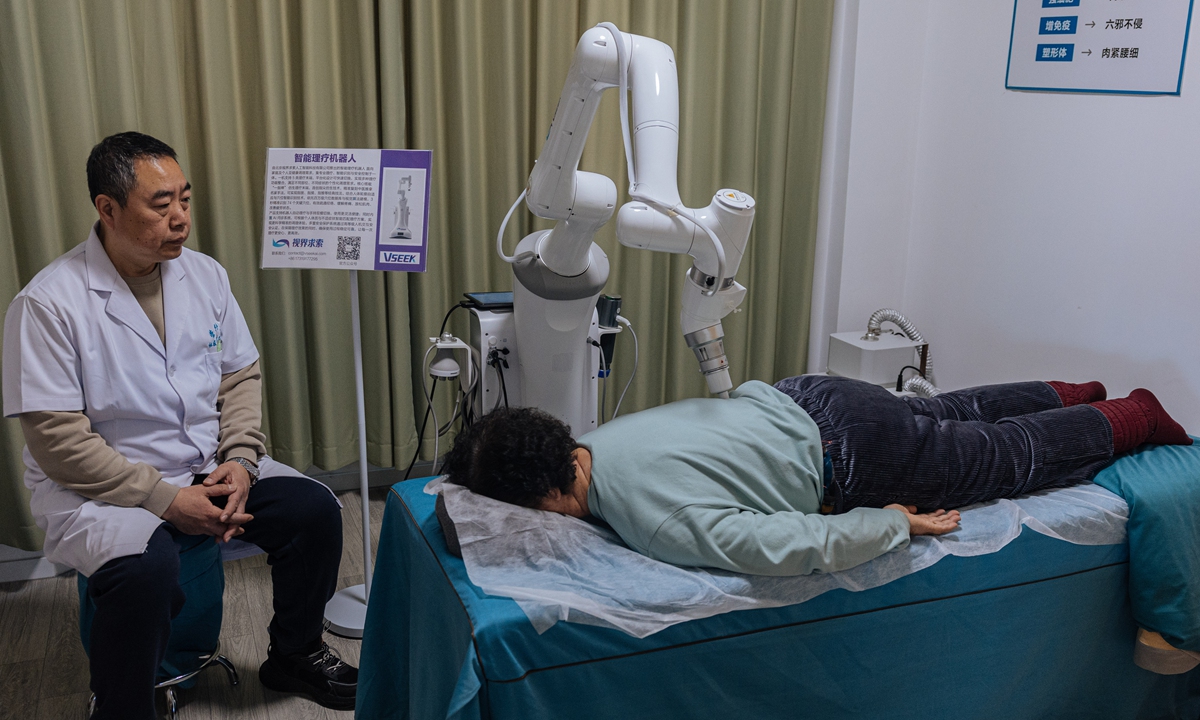 An elderly resident receives a massage from a robot under the supervision of a caregiver in a smart elderly care center in Beijing on March 18, 2025. Photo: Li Hao/GT