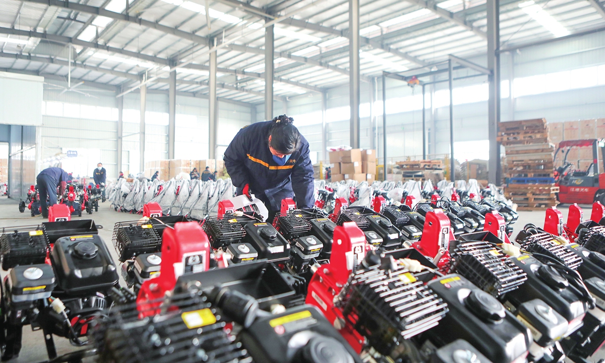 Workers inspect mini tillers bound for India at an agricultural machinery company in Yongchuan, Southwest China