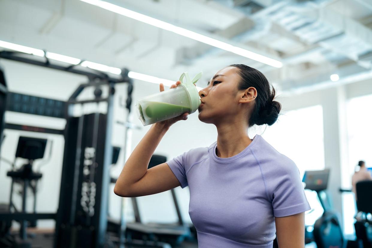 Asian athlete drinking health shake after training session
