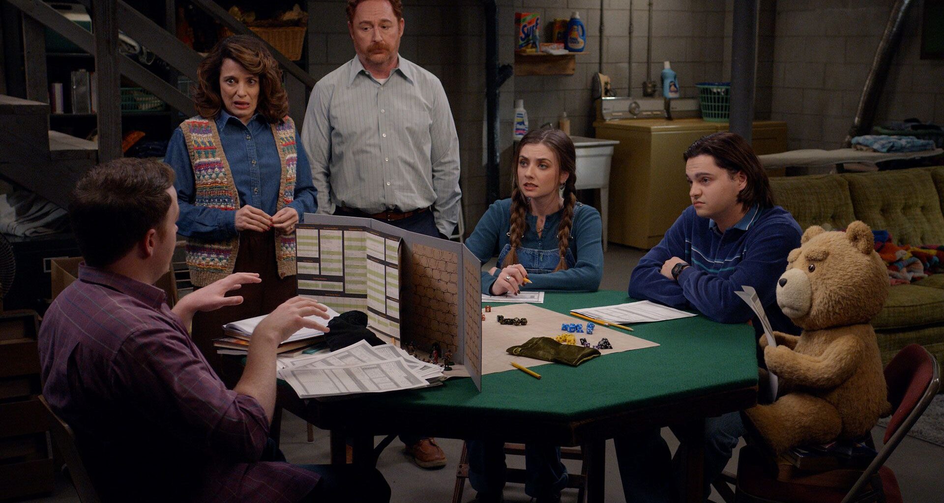 The characters of Ted season 2 sit around a table