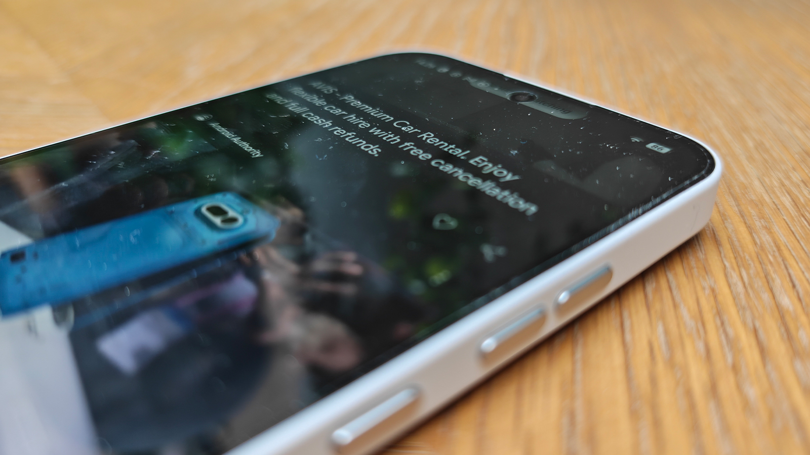 A white smartphone on a wooden desk