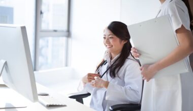 Female doctors and nurses reviewing information on a desktop computer in a clinical setting