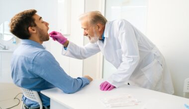 Doctor collecting an oral swab sample from a patient in a clinical setting for pulmonary tuberculosis testing