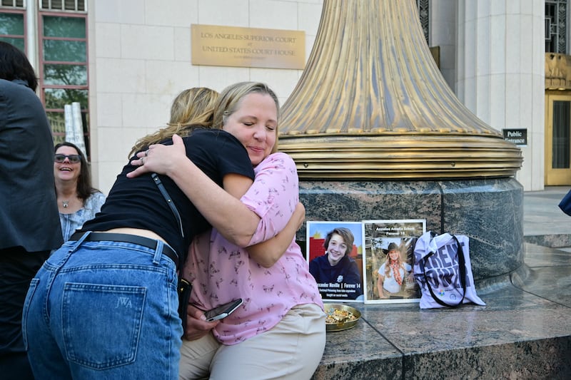 Amy Neville (right), who lost her son Alexander, is greeted by another parent outside the Los Angeles court. Photograph:  Frederic J Brown/AFP/Getty Images