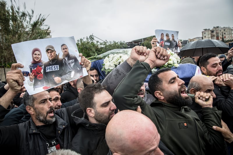 Mourners hold photos of the journalist killed by Israeli air strikes at the funeral procession on Sunday. Photograph: Sally Hayden