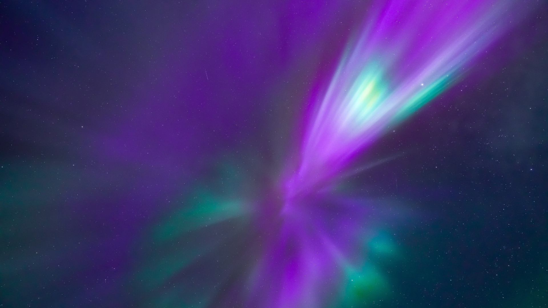 purple and green aurora reach down from directly overhead.