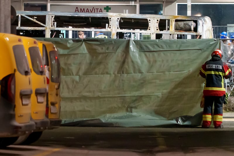 Firefighters and police officers install barriers to secure the area where a bus caught fire in Kerzers, Switzerland. Photograph: Laurent Merlet/Keystone via AP