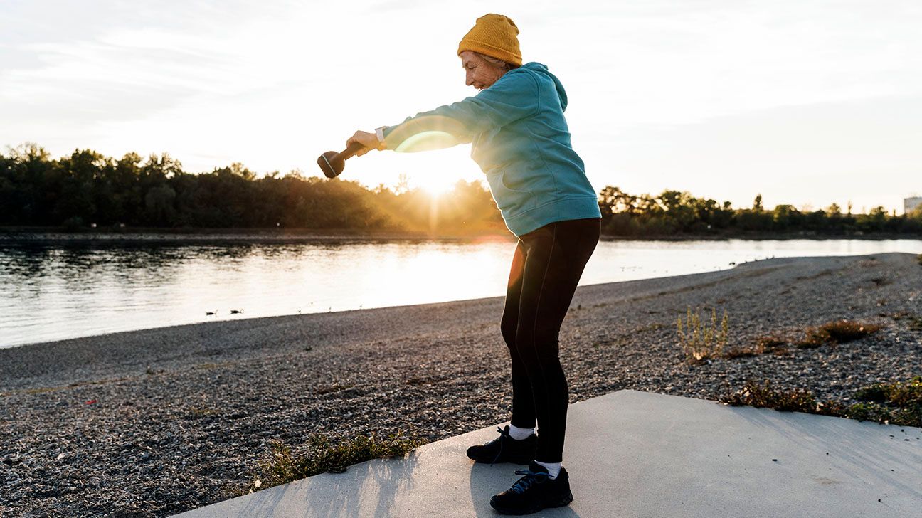 Person exercising outside at sunset near a river
