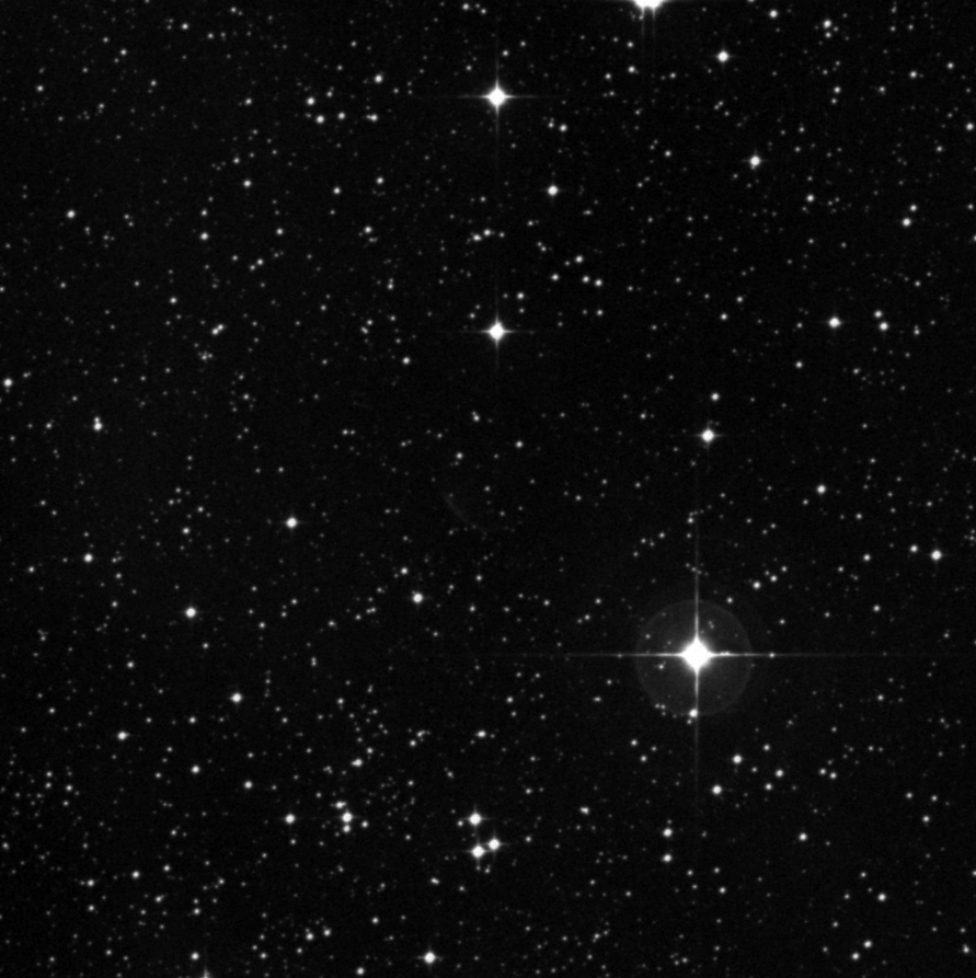 A black and white image shows a star field with numerous stars of varying brightness scattered across the night sky.