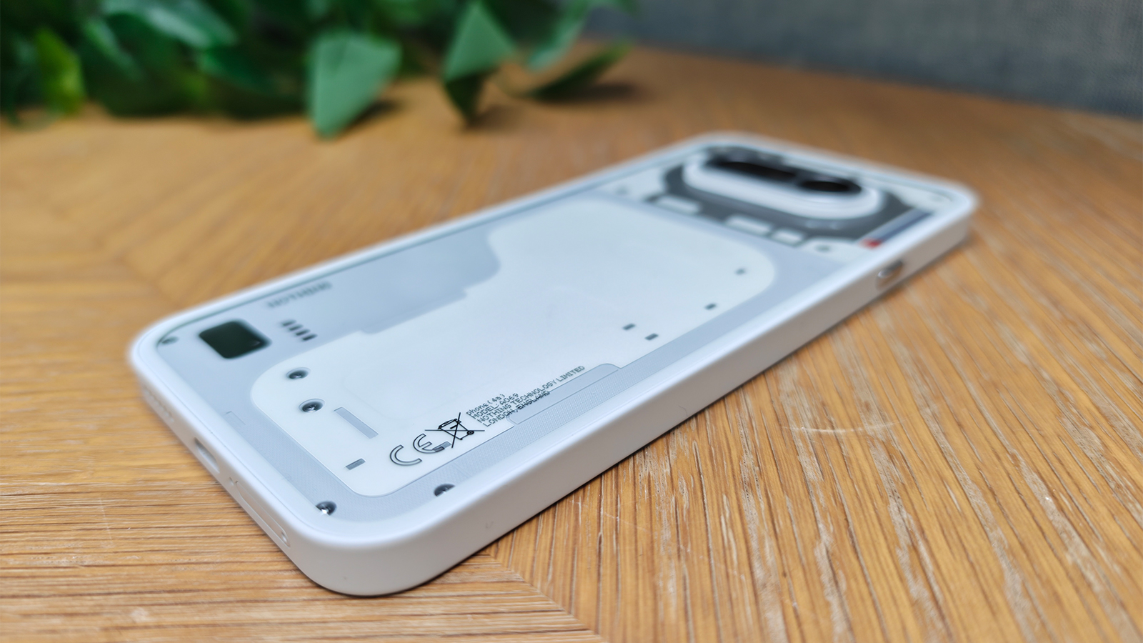 A white smartphone on a wooden desk