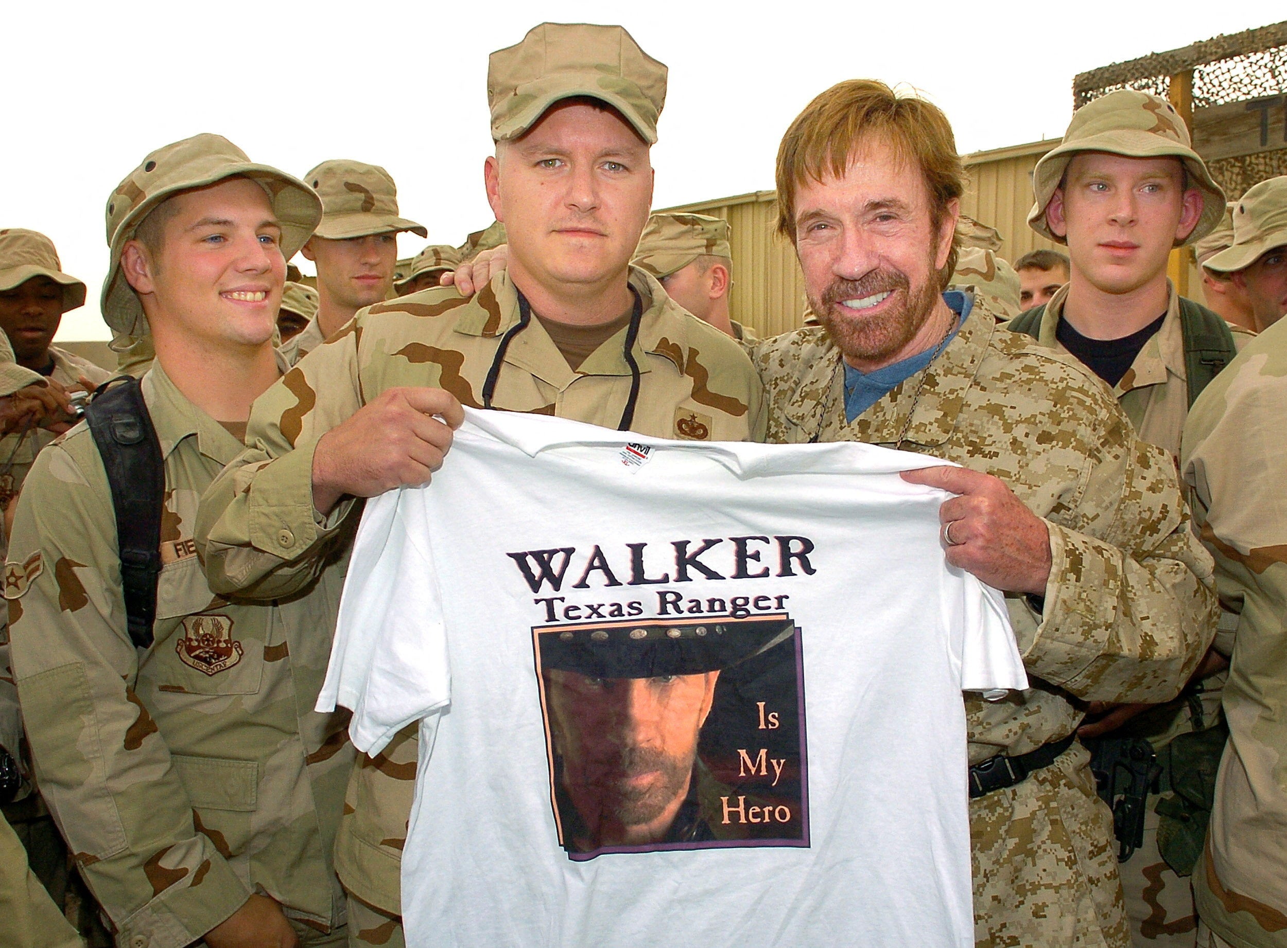 Chuck Norris visiting U.S.troops at Ali Al Saleem Air Base, holding up a T-shirt reading: ‘Walker, Texas Ranger is my hero’