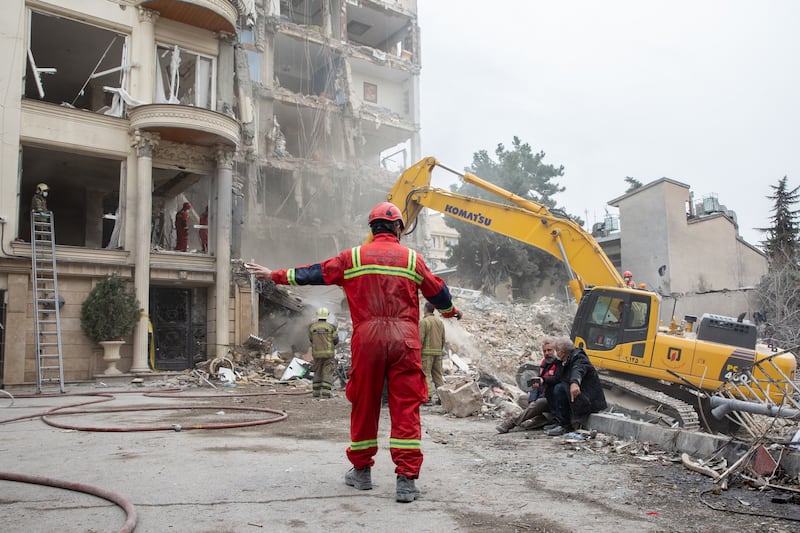 Emergency workers at a residential building that was hit by an air strike in Tehran, on Monday. Photograph: Arash Khamooshi/The New York Times
                      