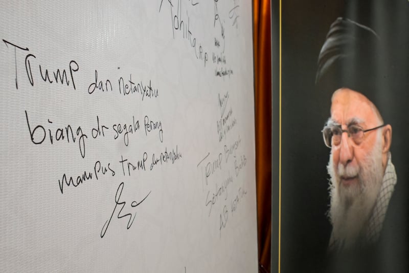 A message reading "Trump and Netanyahu are the root of all wars, death to Trump and Netanyahu" is signed on a whiteboard. Photograph: BAY ISMOYO / AFP via Getty Images