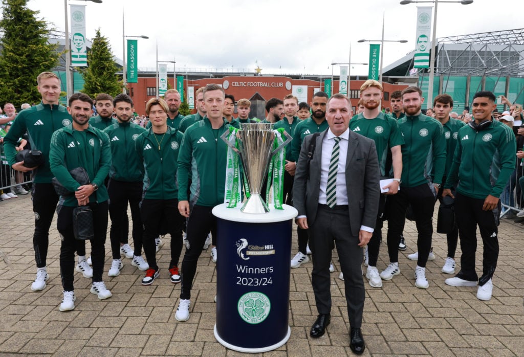 Brendan Rodgers and the Celtic squad pose with the Scottish Premiership trophy outside Celtic Park