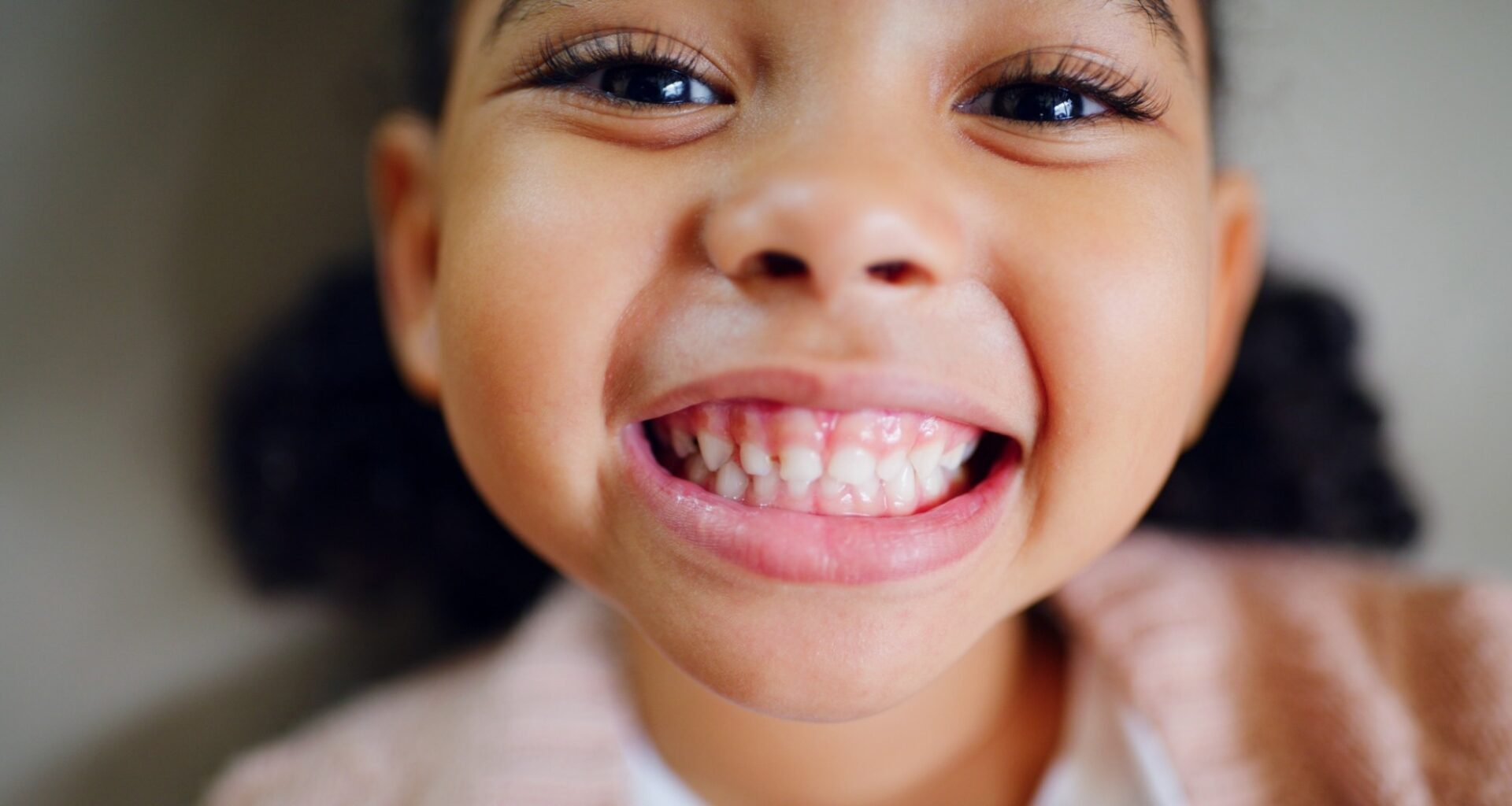 Close up of young girl with big grin showing her teeth