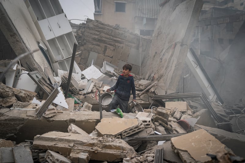 A child searches for kitchen tools among the debris of a building that has collapsed after an IDF air strike in Beirut, Lebanon. Photograph: Adri Salido/Getty Images