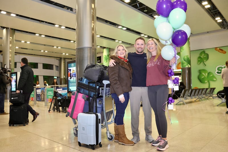 Newly married couple Cathal and Ruth Lynch with Ruth's sister Helen (far left) at Dublin Airport after the couple arrived back from Dubai.