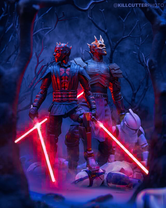 Two Star Wars characters with red lightsabers stand in a dark, foggy forest over fallen clone troopers. The scene is lit with blue and red light, creating a dramatic, intense atmosphere.