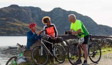 Friends at the bay near the village of Diabaig on the side of Loch Torridon in Wester Ross, Scotland. They are taking a break from their bike ride to relax and chat. They are laughing together.